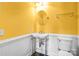 Stylish powder room with pedestal sink, unique gold fixtures, and wainscotting at 305 Chancelot Ln, Fort Mill, SC 29708