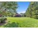 Expansive backyard with lush green grass, mature trees, and a screened porch at 3759 Sand Wedge Dr, Gastonia, NC 28056