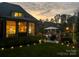 Backyard view featuring a patio, lighting, and a beautifully landscaped yard at sunset at 3759 Sand Wedge Dr, Gastonia, NC 28056