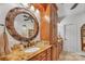 Bathroom features a large round mirror, granite counters, and wood cabinets at 3759 Sand Wedge Dr, Gastonia, NC 28056