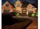 Elegant brick home with manicured landscaping and inviting front entrance at night at 3759 Sand Wedge Dr, Gastonia, NC 28056