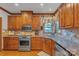 Well-equipped kitchen with stainless steel appliances, wood cabinets, and granite countertops at 3759 Sand Wedge Dr, Gastonia, NC 28056