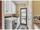 Laundry room featuring modern washer and dryer, cabinets and tile floors at 3759 Sand Wedge Dr, Gastonia, NC 28056
