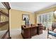 Cozy home office with a large wooden desk, built-in shelving, and natural light from the window at 3759 Sand Wedge Dr, Gastonia, NC 28056