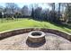 Private backyard with a stone fire pit, brick paver patio and lush greenery at 4124 Sherbrooke Dr, Charlotte, NC 28210