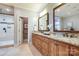 Bathroom featuring double sink vanity, granite countertops, wood cabinets and tiled walk-in shower at 4124 Sherbrooke Dr, Charlotte, NC 28210
