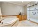 Bright bathroom with soaking tub, tiled shower, neutral colors, and wood storage cabinet at 4124 Sherbrooke Dr, Charlotte, NC 28210