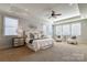 Bright main bedroom featuring tray ceiling, many windows, ceiling fan and sitting area with two chairs at 4124 Sherbrooke Dr, Charlotte, NC 28210