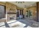 Outdoor patio featuring a stone fireplace, tile flooring, and comfortable seating area at 4124 Sherbrooke Dr, Charlotte, NC 28210
