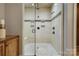 Tiled shower with dual shower heads, built-in seat, and neutral color scheme at 4124 Sherbrooke Dr, Charlotte, NC 28210