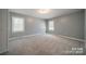 Spacious bedroom featuring neutral walls, carpet flooring, and natural light from the two windows at 6126 Eagle Peak Dr, Charlotte, NC 28214