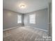 Inviting bedroom features soft gray walls, plush carpet, and two bright windows at 6126 Eagle Peak Dr, Charlotte, NC 28214