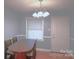 Dining area featuring a modern lamp above a wood dining table with chairs at 6126 Eagle Peak Dr, Charlotte, NC 28214