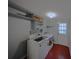 Bright laundry room with modern washer and dryer units, storage shelves, and a back door at 6126 Eagle Peak Dr, Charlotte, NC 28214