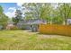 Backyard featuring a grey brick house, a wooden fence and mature trees providing shade at 6813 Elm Forest Dr, Charlotte, NC 28212