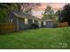Spacious backyard featuring a well-maintained lawn, privacy fence, and sunset sky at 6813 Elm Forest Dr, Charlotte, NC 28212