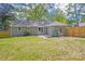 A fully fenced-in backyard with a grey brick house and mature tree coverage at 6813 Elm Forest Dr, Charlotte, NC 28212