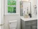 Bathroom with updated vanity, granite counters, gold hardware, and bright window at 6813 Elm Forest Dr, Charlotte, NC 28212