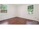 A bedroom with hardwood floors and two windows providing natural light at 6813 Elm Forest Dr, Charlotte, NC 28212
