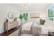 Bright bedroom featuring a dresser, round mirror, and view to the outdoors at 6813 Elm Forest Dr, Charlotte, NC 28212