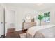 Bright bedroom featuring a dresser, round mirror, decorative lighting, and hardwood floors at 6813 Elm Forest Dr, Charlotte, NC 28212