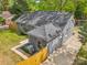 Aerial shot of a gray brick home with a dark roof, a fenced-in yard, and a paved driveway for easy parking at 6813 Elm Forest Dr, Charlotte, NC 28212