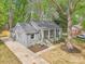 Charming gray brick home with a welcoming porch, a well-manicured yard, and a paved driveway at 6813 Elm Forest Dr, Charlotte, NC 28212