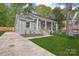 Charming gray brick home with a welcoming front porch and a well-manicured lawn at 6813 Elm Forest Dr, Charlotte, NC 28212
