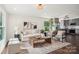 Sunlit living room featuring stylish decor, with gray trim, and open access to the modern kitchen at 6813 Elm Forest Dr, Charlotte, NC 28212