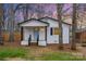 Charming white brick home featuring a blue front door, black trim, and a cozy front porch at 735 Green St, Rock Hill, SC 29730