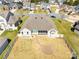 Aerial view of the home showcasing the backyard with a stone patio and walkway, surrounded by a white fence at 7362 Vanguard Ct, Stanley, NC 28164