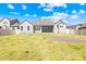 Beautiful backyard features green lawn, neutral siding, white fence, and brick patio space for outdoor entertaining at 7362 Vanguard Ct, Stanley, NC 28164