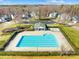 Aerial view of the community pool, playground, and clubhouse in a well-maintained neighborhood at 7362 Vanguard Ct, Stanley, NC 28164