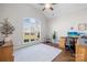 A well-lit home office with hardwood floors, a large window, and a vaulted ceiling creates an inviting workspace at 7362 Vanguard Ct, Stanley, NC 28164