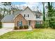 Charming two-story home with a brick facade, green lawn, and beautiful landscaping at 7921 Altacrest Dr, Concord, NC 28027