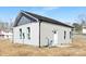 Side exterior view of a charming house with light grey siding, a dark grey roof and well-lit windows at 921 Park Dr, Statesville, NC 28677