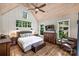 Bright bedroom features wood flooring, a ceiling fan, and large windows with views of the surrounding greenery at Lot 17 Ridgeview Ln, Iron Station, NC 28080