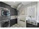 A modern laundry room with a stacked washer and dryer, ample cabinets, and a dog wash area at Lot 17 Ridgeview Ln, Iron Station, NC 28080