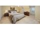 Cozy staged bedroom with beige walls, a large bed, and a nature painting above the headboard at 10349 Linksland Dr, Huntersville, NC 28078