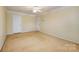 Large beige bedroom featuring two white doors, overhead lighting, and neutral carpet flooring at 10349 Linksland Dr, Huntersville, NC 28078