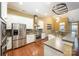Stylish kitchen featuring stainless steel appliances, white cabinets, and hardwood flooring at 10349 Linksland Dr, Huntersville, NC 28078