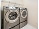 Convenient laundry area with front load washer and dryer and storage space at 10349 Linksland Dr, Huntersville, NC 28078