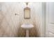 Stylish powder room featuring wallpaper, a pedestal sink, and decorative mirror at 10349 Linksland Dr, Huntersville, NC 28078