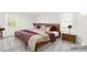 Bedroom with a bed, two side tables, stylish decor, and natural light from the windows at 1133 Bloom Wood Ln, Matthews, NC 28105
