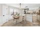 Bright dining area featuring a wooden table, seating for four, and modern lighting fixture next to the kitchen at 1133 Bloom Wood Ln, Matthews, NC 28105