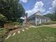 Charming gray home featuring a spacious deck, landscaped front yard, and inviting walkway at 1133 Bloom Wood Ln, Matthews, NC 28105