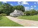 A well-maintained two-story home boasts a long driveway, manicured lawn, and classic curb appeal under a blue sky at 1133 Bloom Wood Ln, Matthews, NC 28105