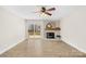 Bright living room with a fireplace, hardwood floors, ceiling fan, and sliding glass doors to the deck at 1133 Bloom Wood Ln, Matthews, NC 28105