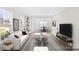 Staged living room featuring hardwood floors, built-in shelving, a white sofa, and stylish decor at 1133 Bloom Wood Ln, Matthews, NC 28105