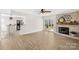 Open living room with fireplace, ceiling fan, hardwood floors, and sliding glass doors to the deck. Kitchen to the left at 1133 Bloom Wood Ln, Matthews, NC 28105